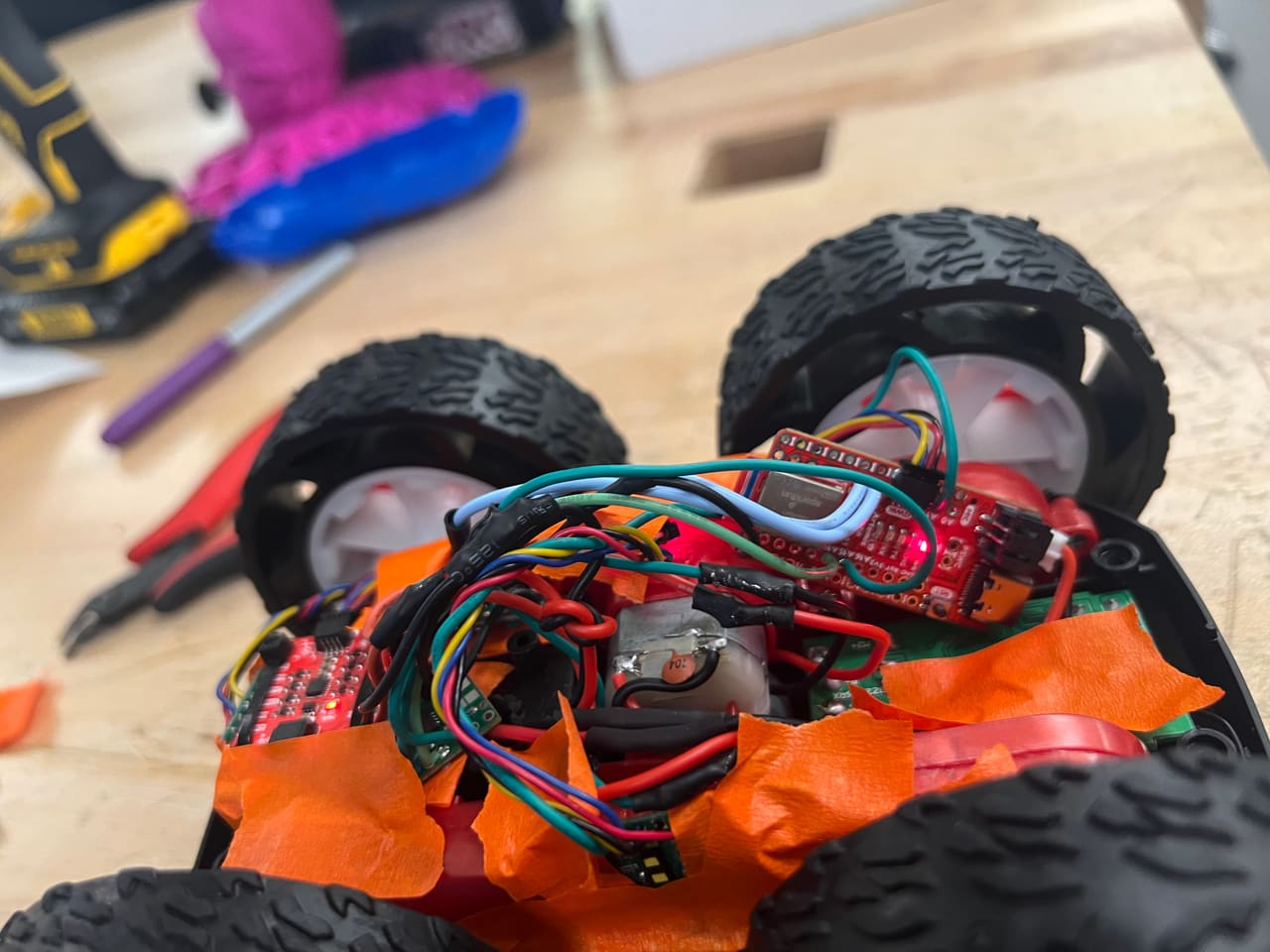 The robot on a workbench, wiring loom and sensors visible, tools and 3D prints around it.